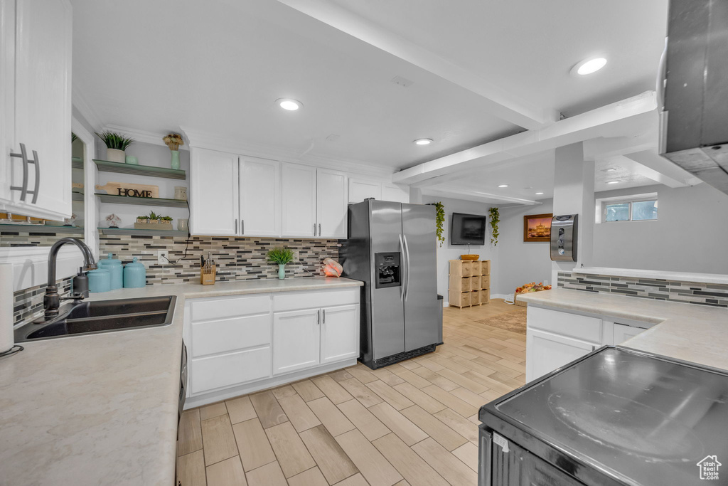 Kitchen with stainless steel appliances, backsplash, light countertops, open shelves, and recessed lighting
