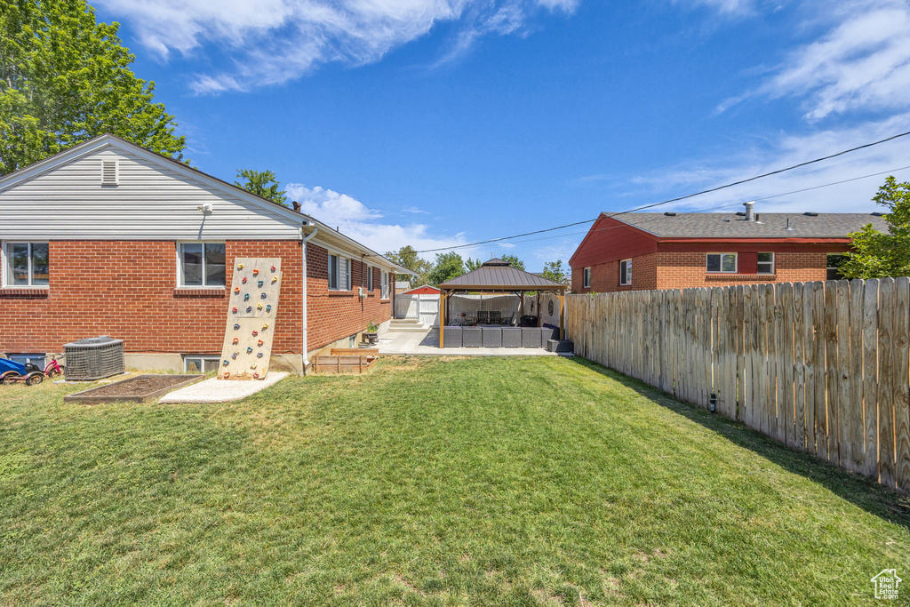 Fenced backyard featuring a gazebo and a patio