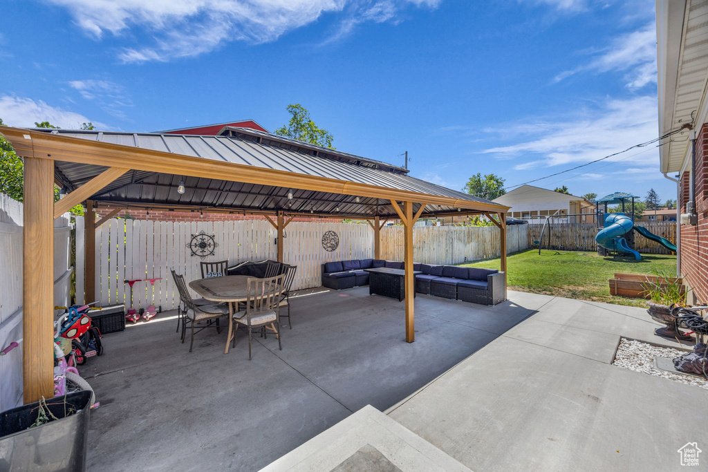 Fenced backyard featuring an outdoor living space, a gazebo, a playground, and a patio