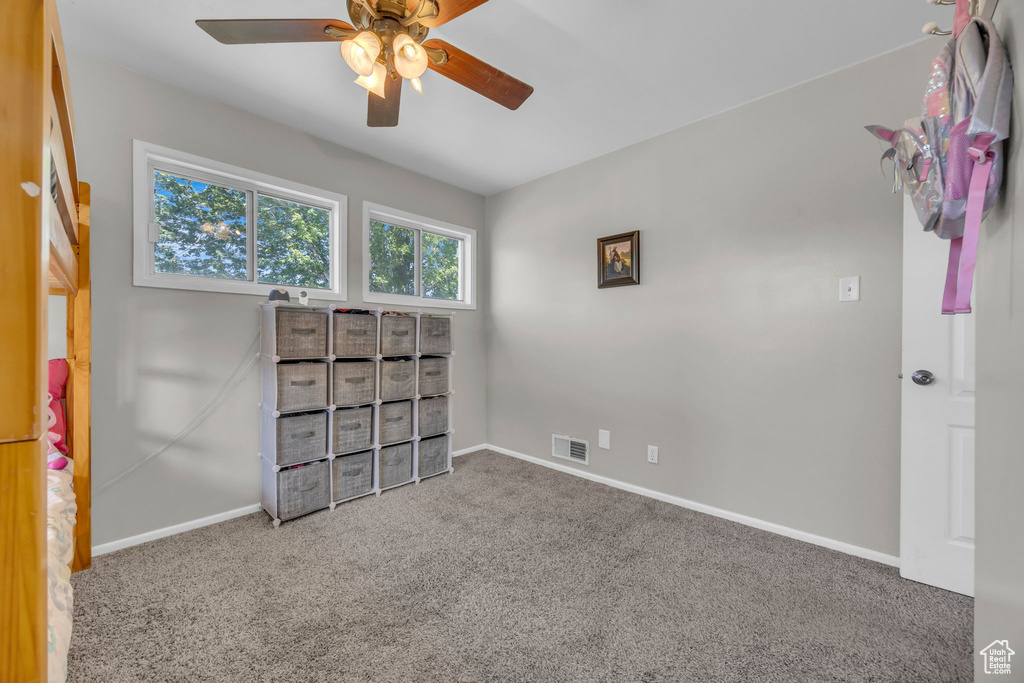 Spare room with a ceiling fan and carpet flooring