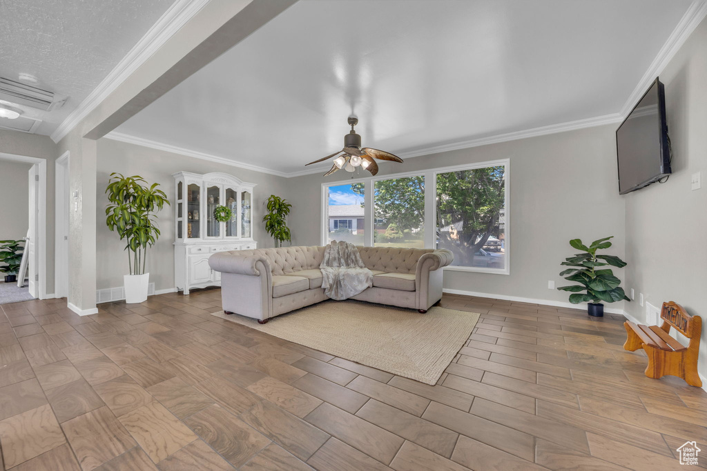 Living area with a ceiling fan and crown molding