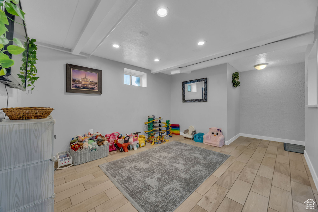 Game room featuring light wood finished floors, beam ceiling, and recessed lighting