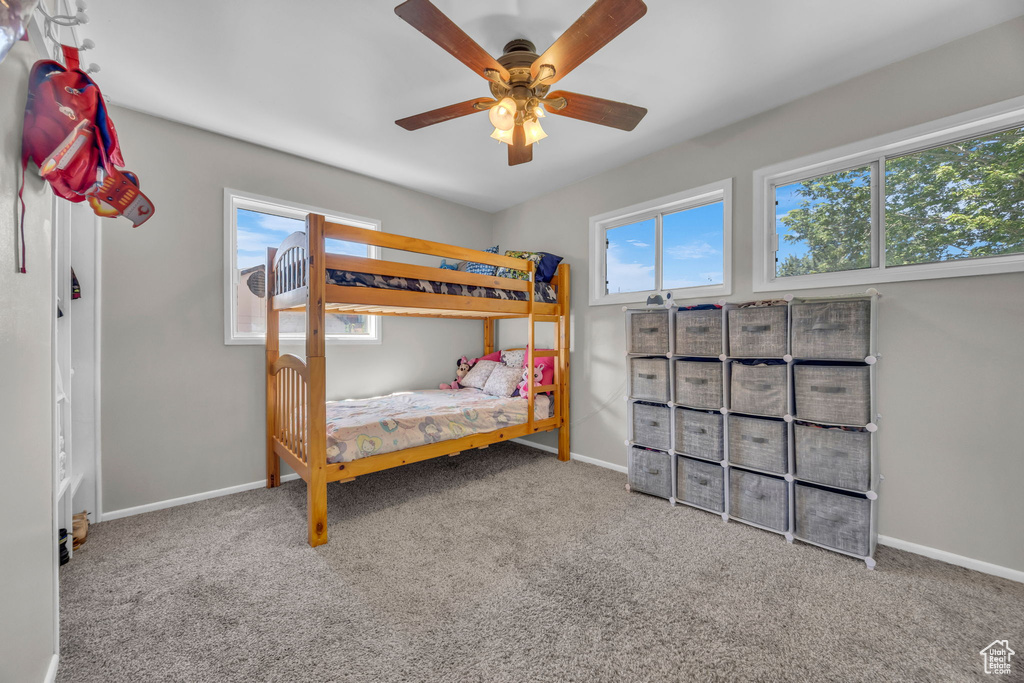Carpeted bedroom featuring baseboards and a ceiling fan