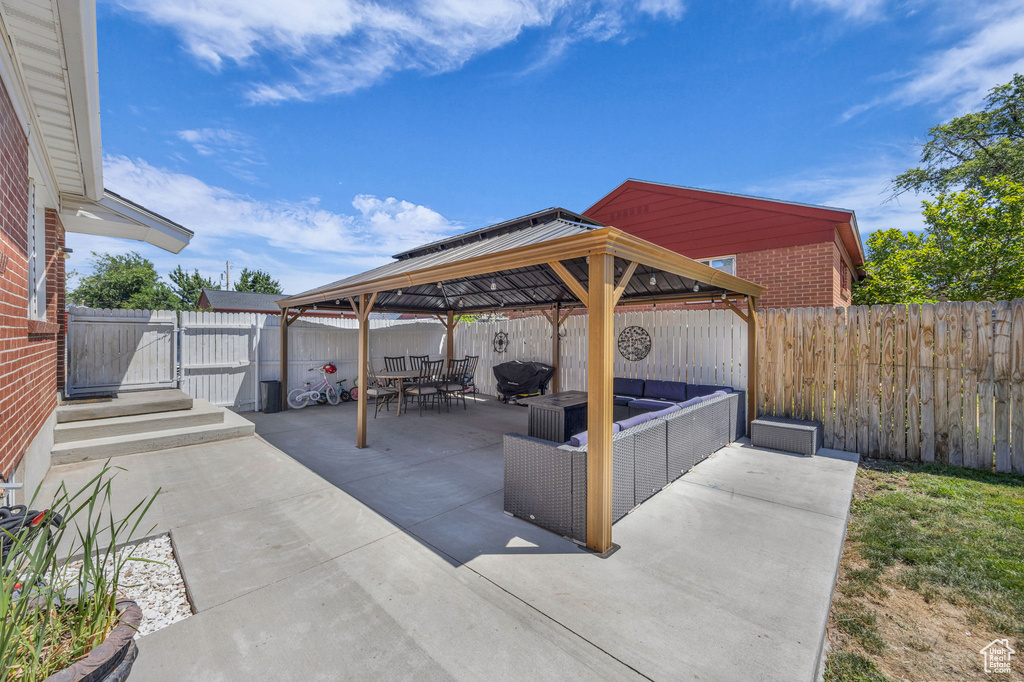 Fenced backyard featuring a gazebo, an outdoor living space, a patio, and outdoor dining space