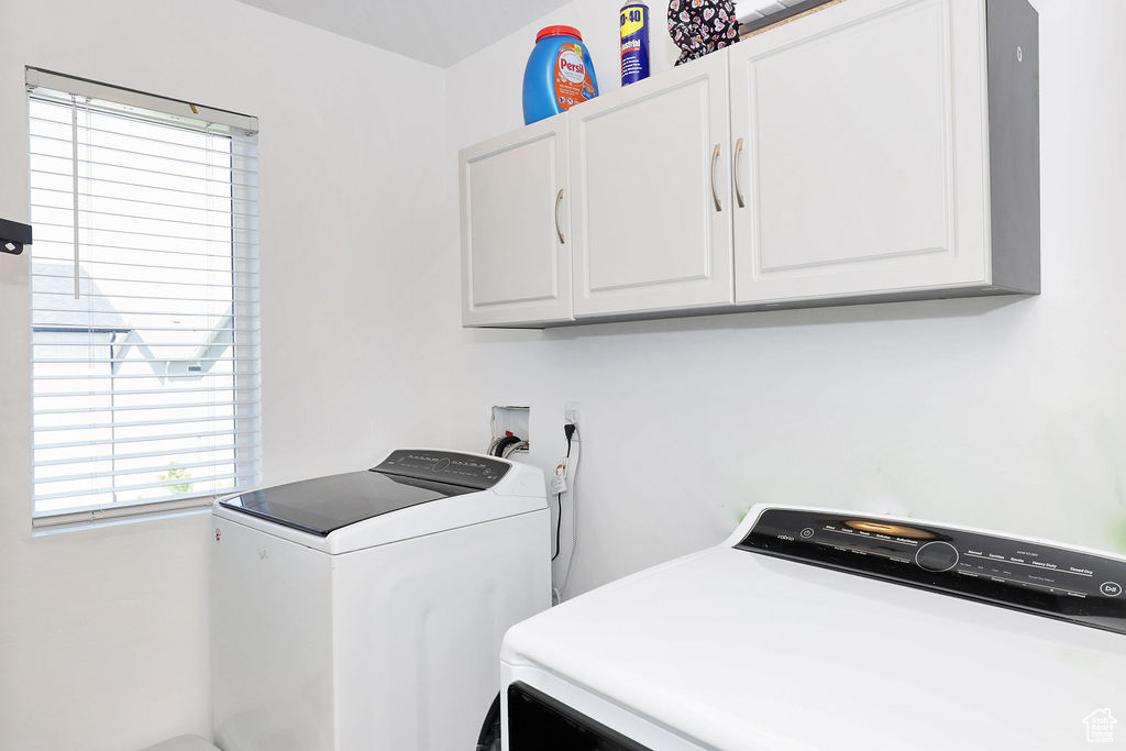 Laundry area with cabinet space, washer and clothes dryer, and plenty of natural light