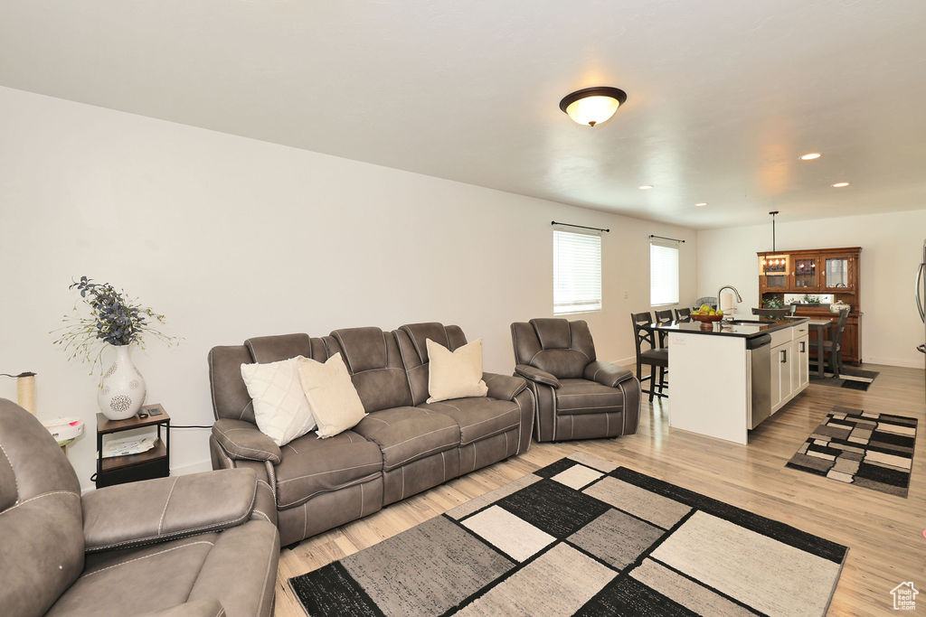Living area with light wood-style flooring and recessed lighting