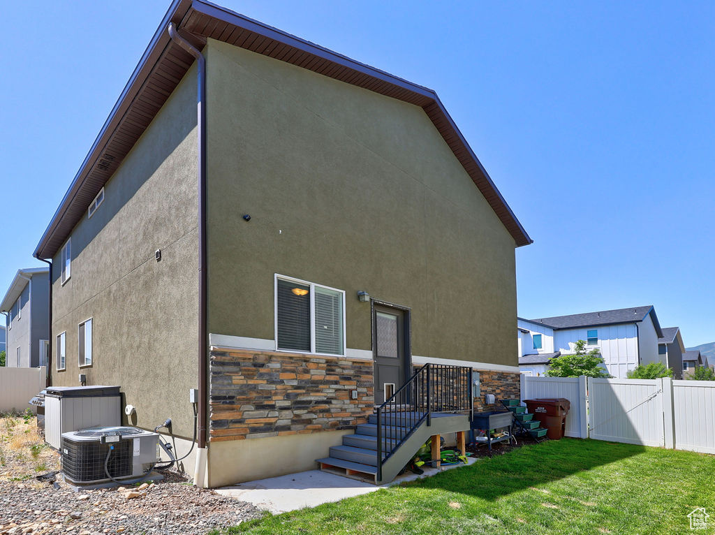 Rear view of property with stucco siding, stone siding, and a gate