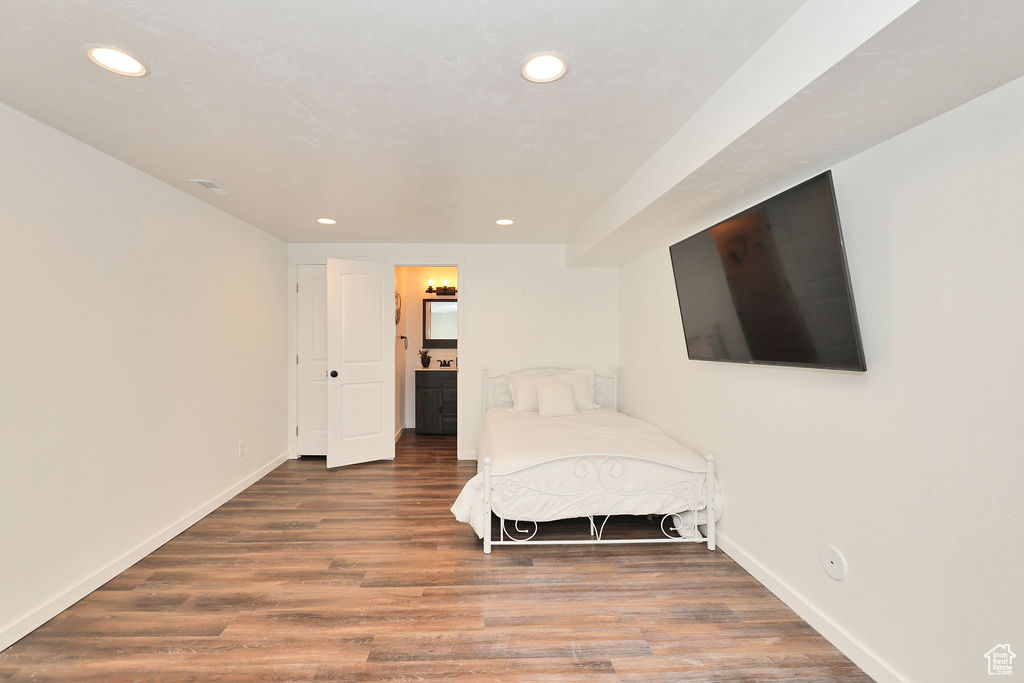 Bedroom with recessed lighting, wood finished floors, and connected bathroom