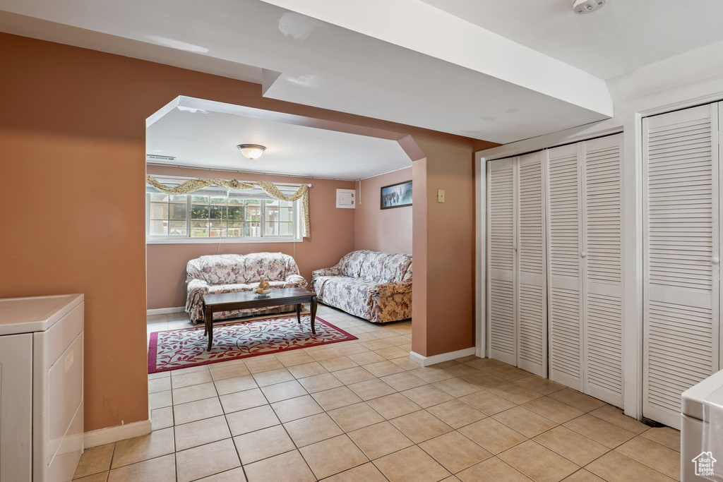 Living room featuring washer / dryer, arched walkways, and light tile patterned flooring