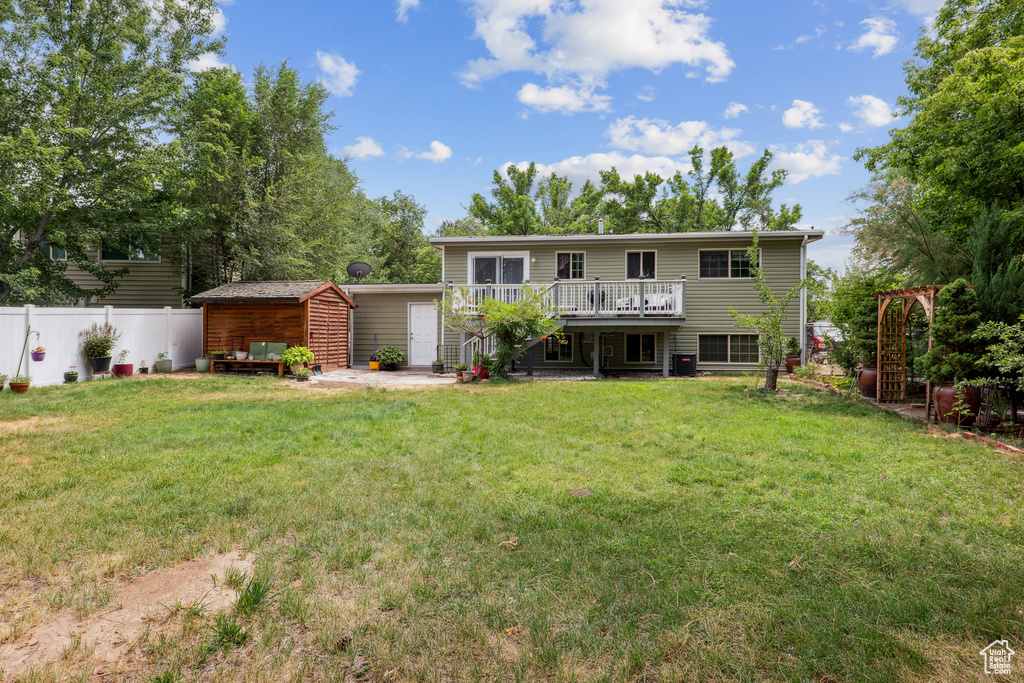 Back of property with a deck and a storage shed