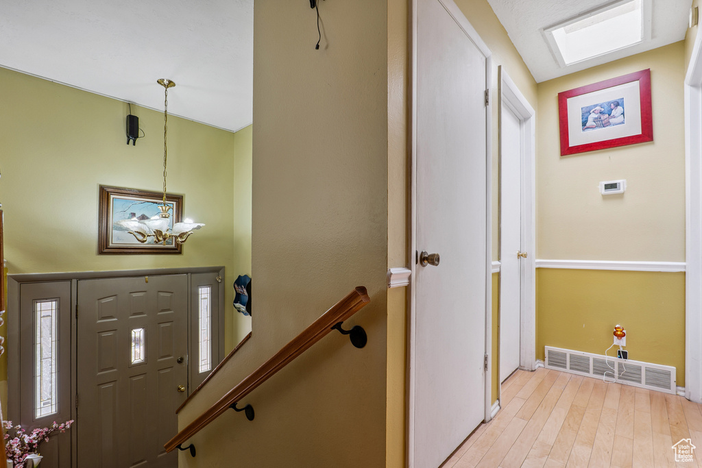Foyer with light wood-type flooring and baseboards