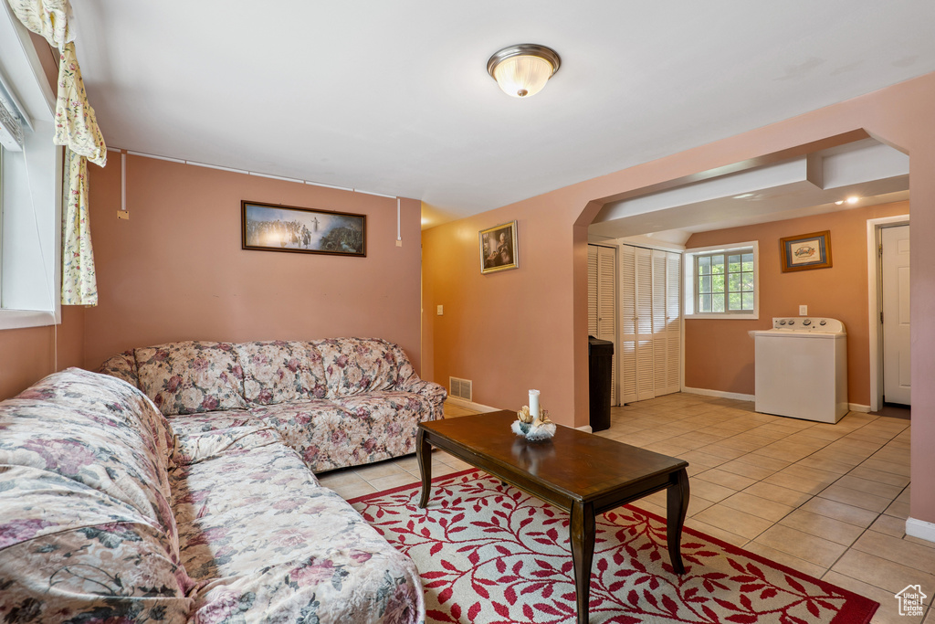 Tiled living room with washer / dryer and arched walkways
