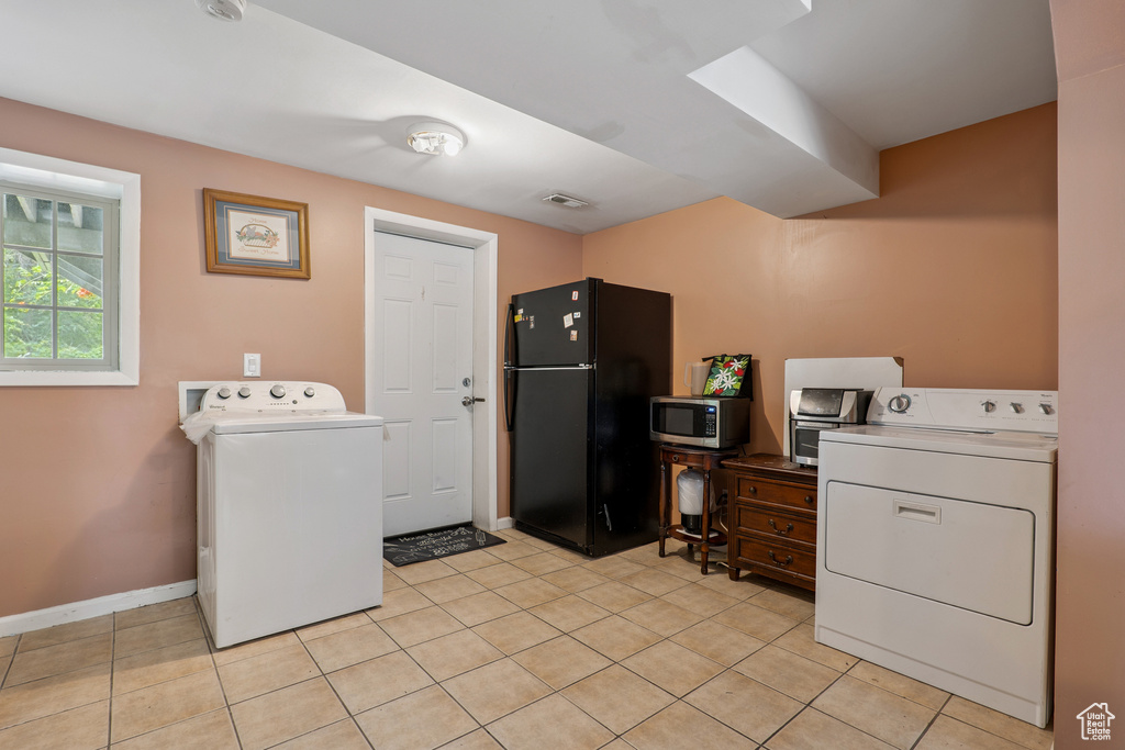 Laundry room with washer / dryer and light tile patterned floors