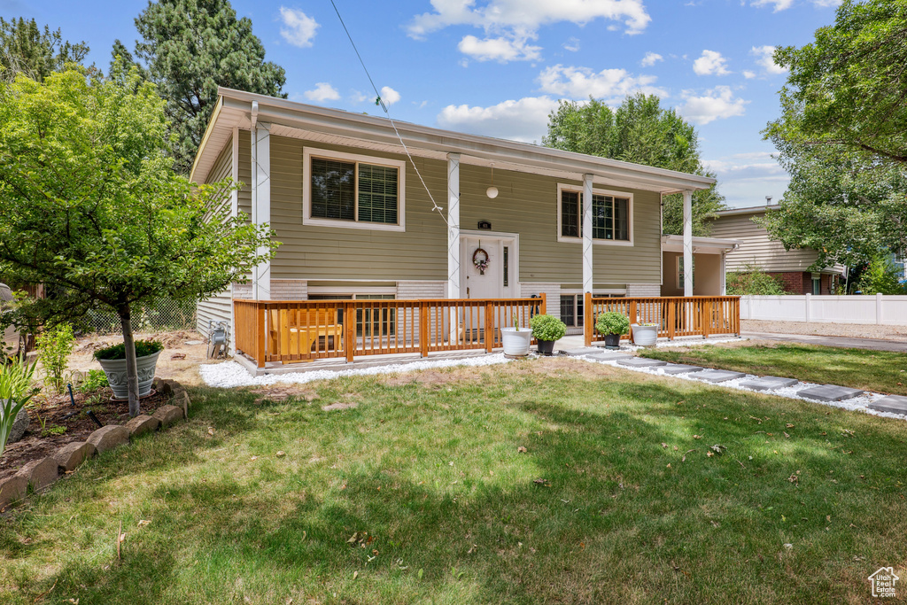 Bi-level home featuring a front yard and covered porch