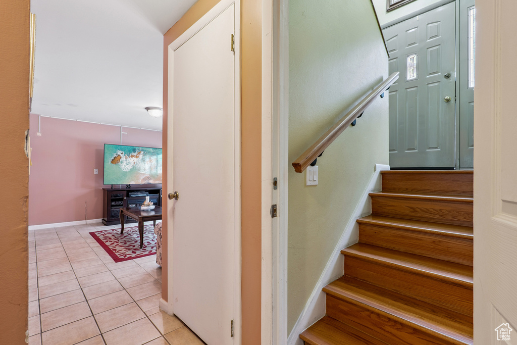 Stairs featuring tile patterned floors and baseboards