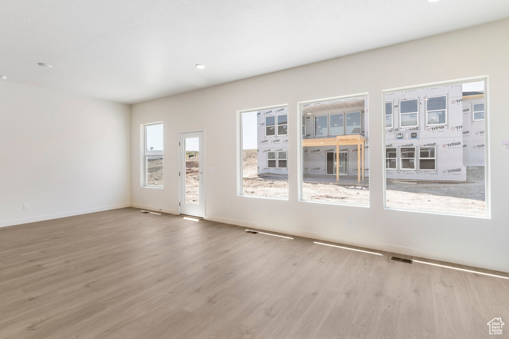 Unfurnished living room featuring wood finished floors and baseboards