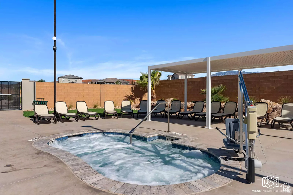 View of swimming pool with a hot tub, a patio, a fenced backyard, and a pool