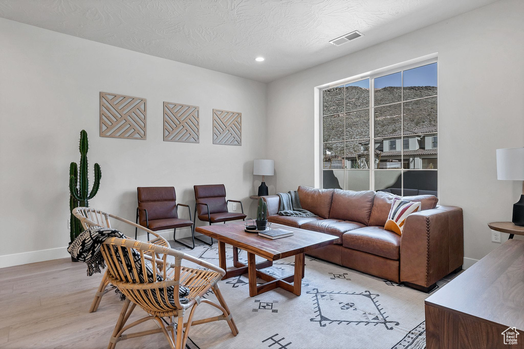 Living room featuring light wood-style flooring, recessed lighting, and a textured ceiling