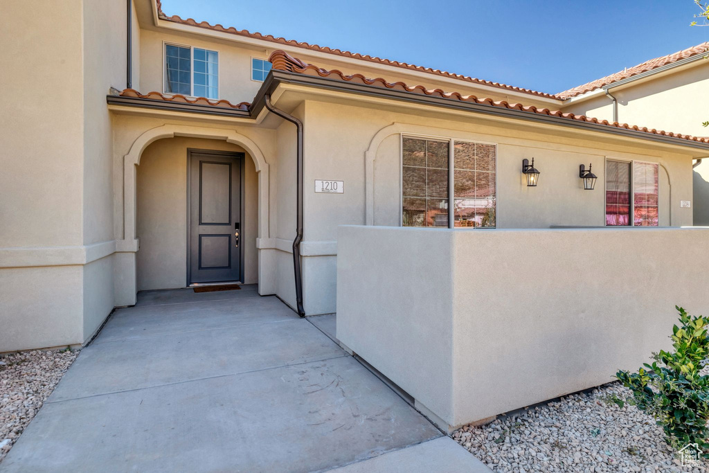 Doorway to property with stucco siding and a tile roof