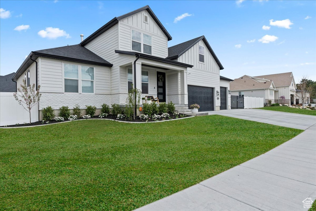 Modern farmhouse with board and batten siding, concrete driveway, a porch, an attached garage, and brick siding