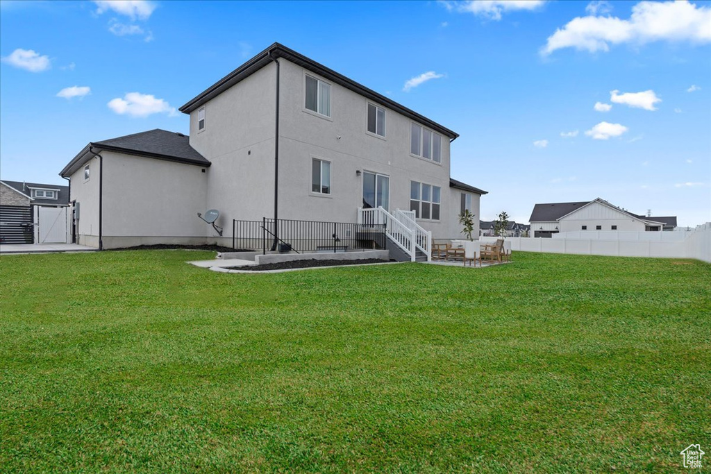 Rear view of property featuring stucco siding and a gate