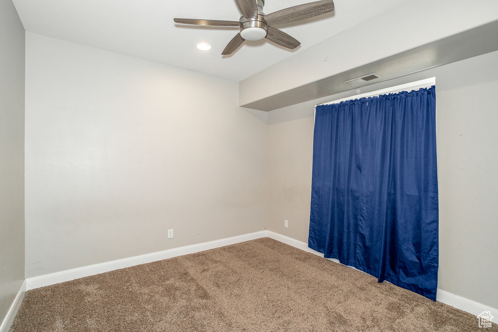 Carpeted empty room featuring ceiling fan and recessed lighting