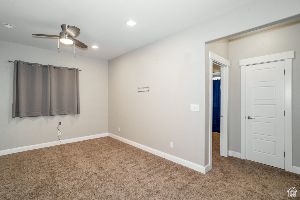 Carpeted spare room featuring ceiling fan and recessed lighting