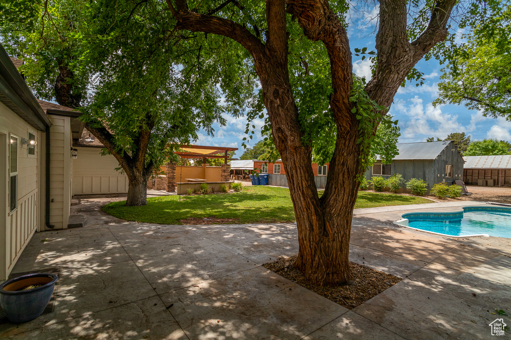 View of swimming pool featuring a patio and a yard