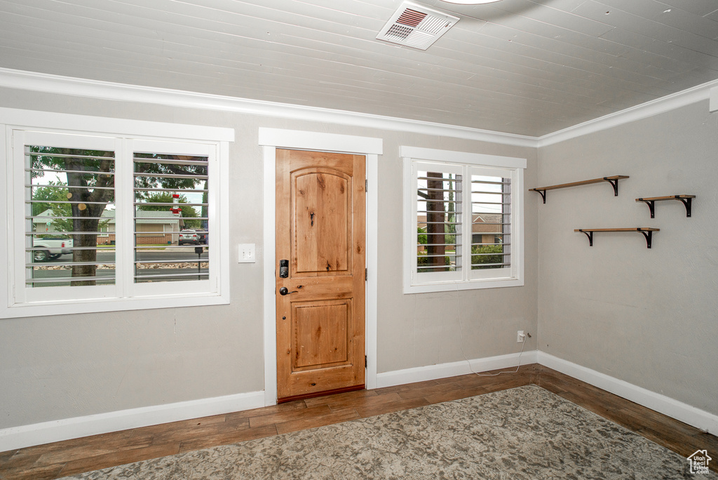 Foyer with wood finished floors and ornamental molding
