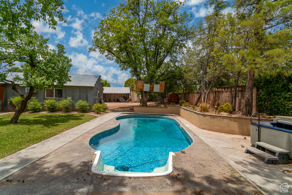 View of swimming pool featuring a fenced backyard, a patio, and a hot tub