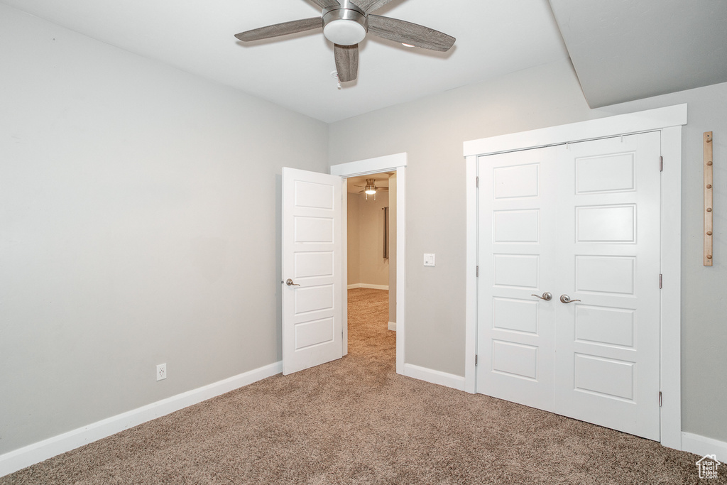Unfurnished bedroom with carpet floors, a closet, and a ceiling fan
