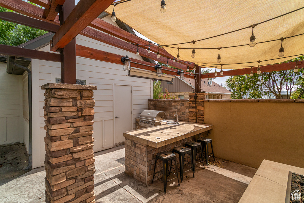 View of patio featuring a pergola and an outdoor kitchen
