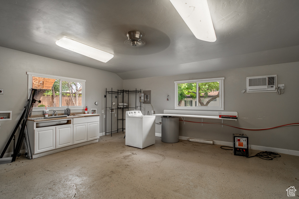 Washroom featuring washer / clothes dryer, an AC wall unit, and electric panel