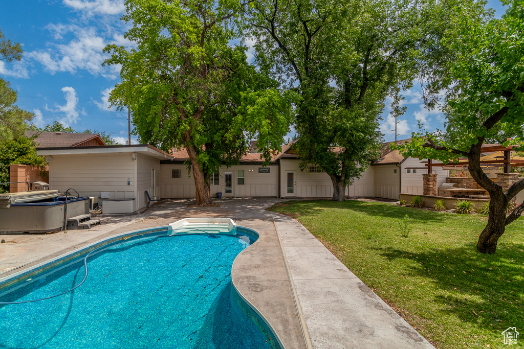 View of swimming pool with a lawn and a patio