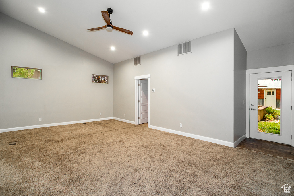 Carpeted empty room with ceiling fan, lofted ceiling, and recessed lighting