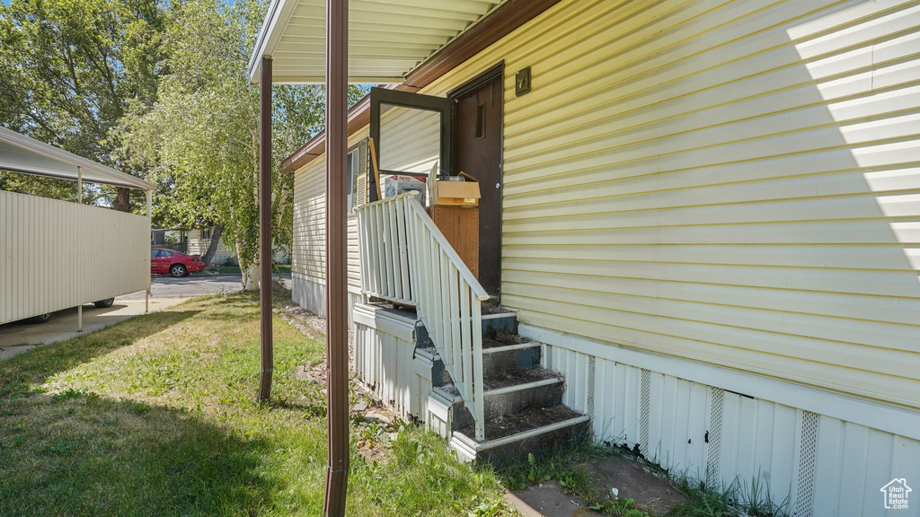 View of side of property with a lawn and entry steps