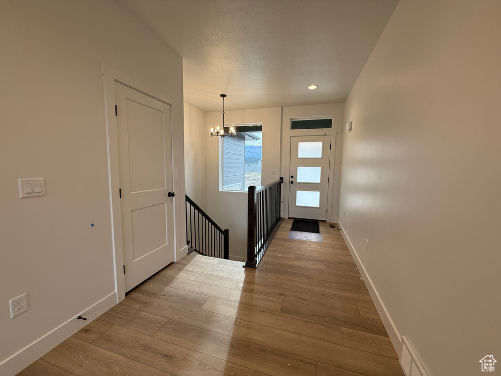 Doorway to outside with a chandelier, hardwood / wood-style flooring, and recessed lighting