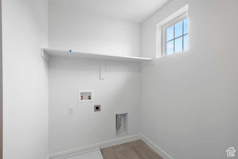 Laundry room with hookup for a washing machine, hookup for an electric dryer, and light wood-type flooring