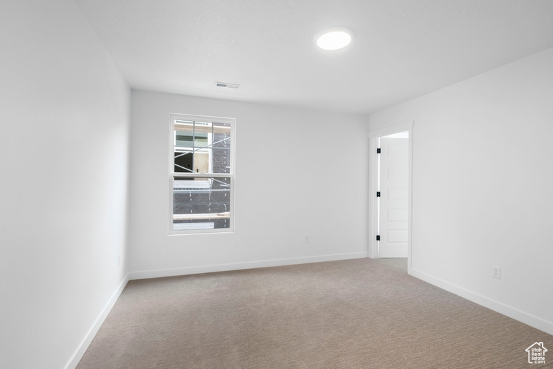 Carpeted empty room featuring baseboards