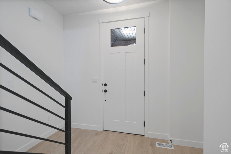 Entryway with light wood-style floors and stairway