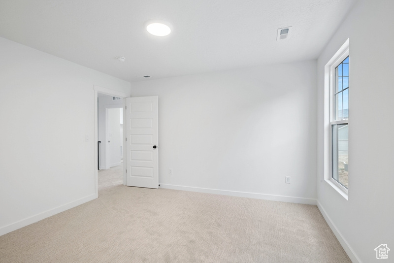 Spare room with light carpet and plenty of natural light