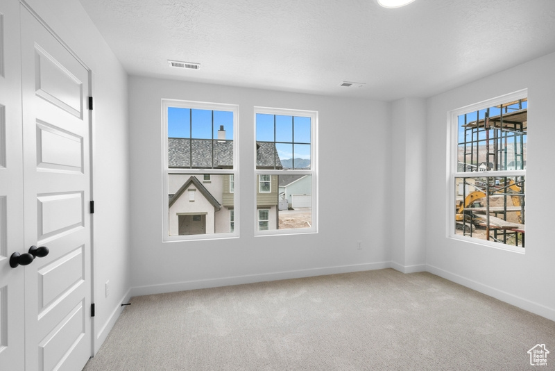 Carpeted empty room with baseboards