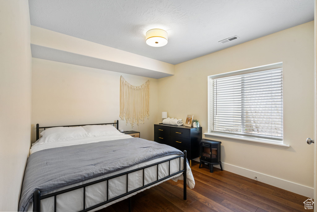 Bedroom with baseboards and dark wood-style floors