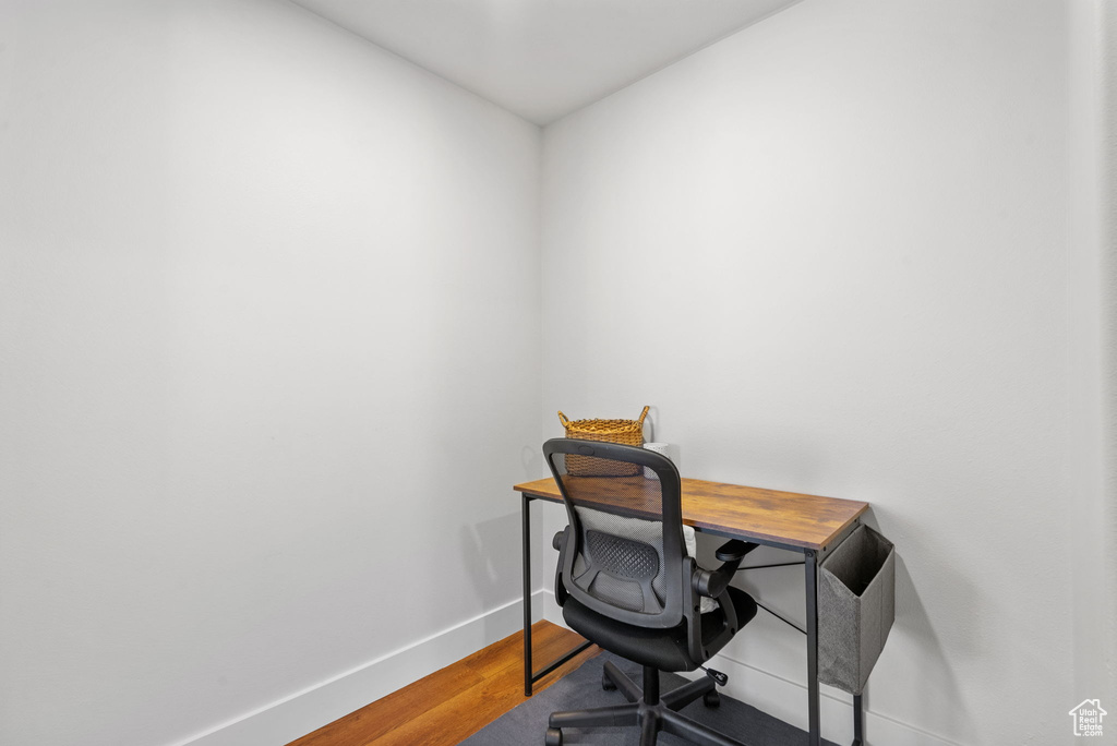 Home office with baseboards and wood finished floors