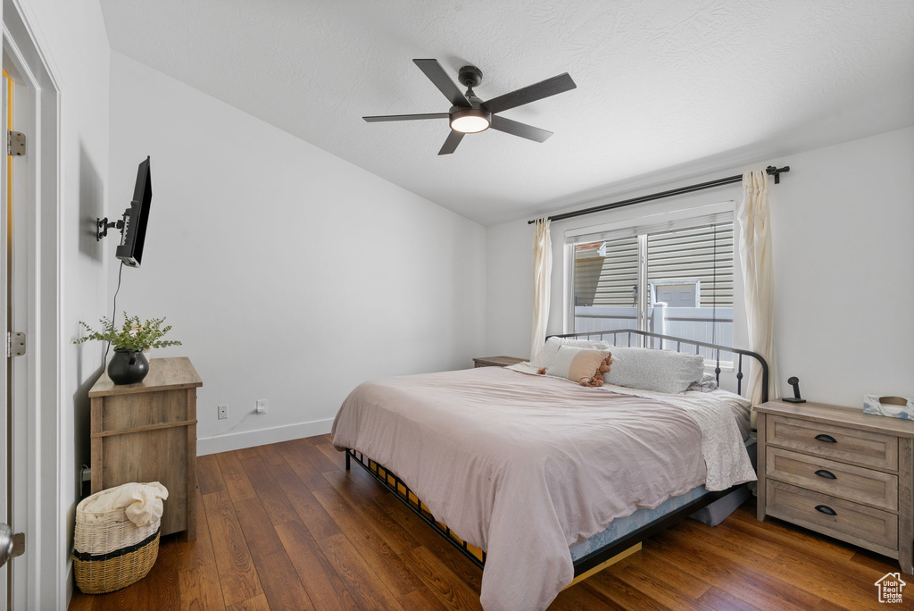 Bedroom featuring dark wood-type flooring, lofted ceiling, and a ceiling fan