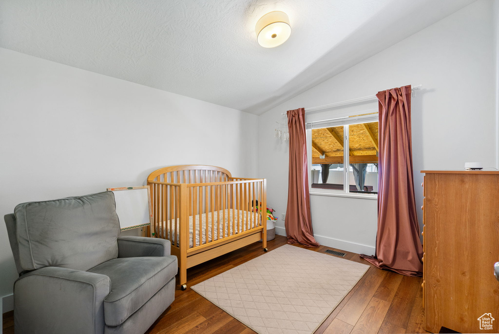Bedroom with lofted ceiling and wood finished floors