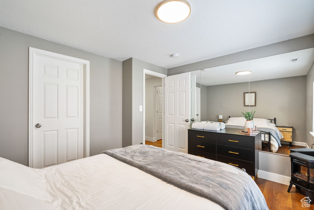 Bedroom with dark wood-style flooring and baseboards
