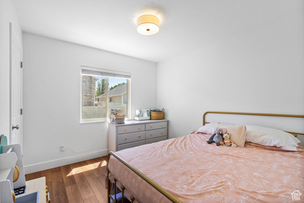 Bedroom featuring wood finished floors and baseboards