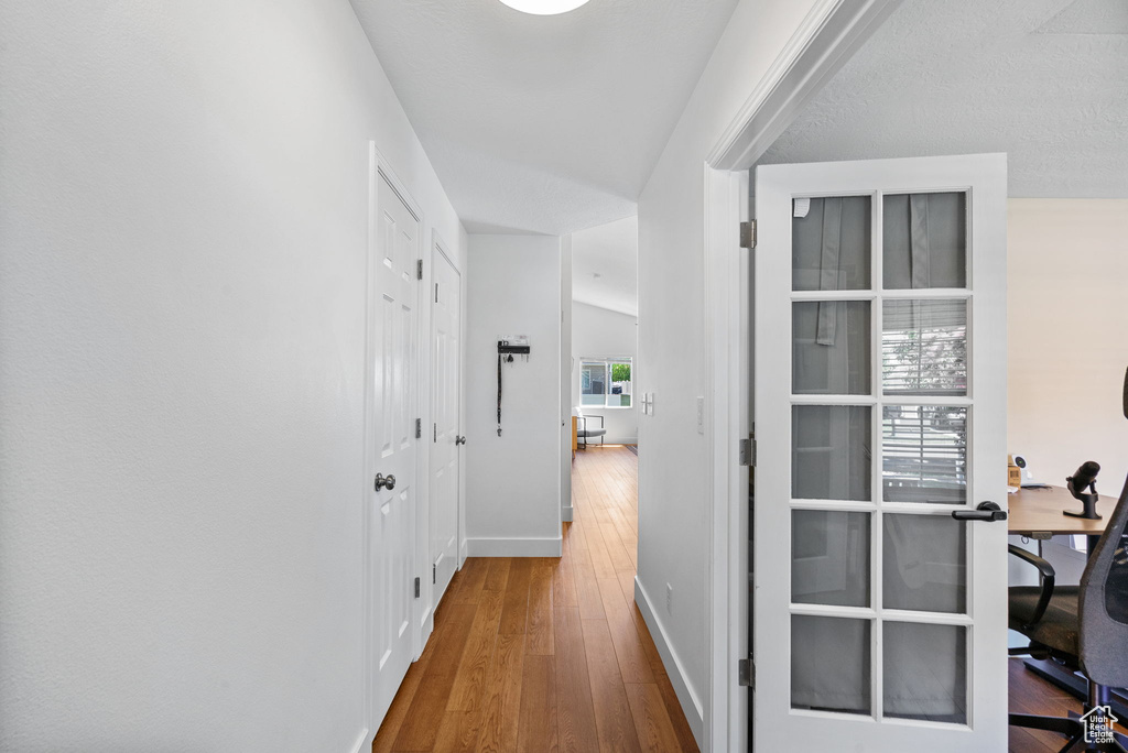 Hallway with hardwood / wood-style flooring and a desk