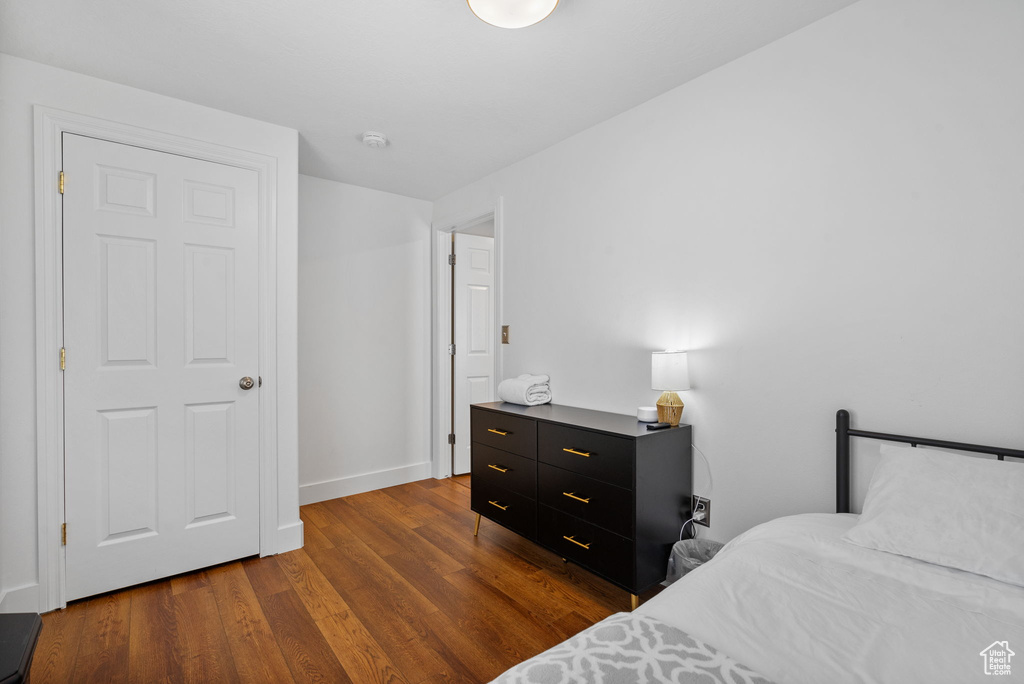 Bedroom with wood finished floors and baseboards